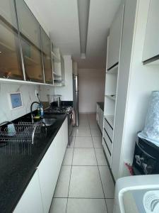 a kitchen with white cabinets and a black counter top at Ap Guanabara-Liberdade-Pertinho de Tudo-Central in Porto Velho