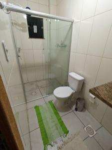 ein Badezimmer mit einer Dusche und einem WC mit einem grünen Teppich in der Unterkunft Ap Guanabara-Liberdade-Pertinho de Tudo-Central in Porto Velho