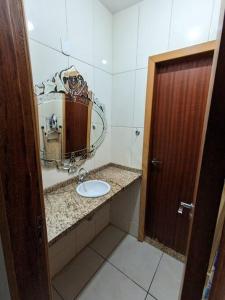 een badkamer met een wastafel en een spiegel bij Ap Guanabara-Liberdade-Pertinho de Tudo-Central in Porto Velho