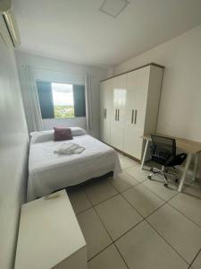 a bedroom with a bed and a desk and a chair at Ap Guanabara-Liberdade-Pertinho de Tudo-Central in Porto Velho