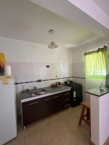 eine Küche mit Spüle und Kühlschrank in der Unterkunft Maraja in Mar de Ajó