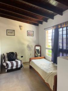 a bedroom with two beds and a window with a fan at Maraja in Mar de Ajó