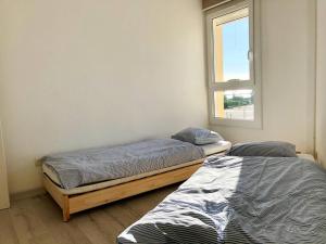 zwei Einzelbetten in einem Zimmer mit Fenster in der Unterkunft T3 climatisé, 3*, 50m de la plage, garage, wifi inclus - FR-1-610-37 in Bormes-les-Mimosas