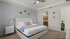 a white bedroom with a bed and a bathroom at Amazing Villas 20 minutes away from Disney! in Kissimmee
