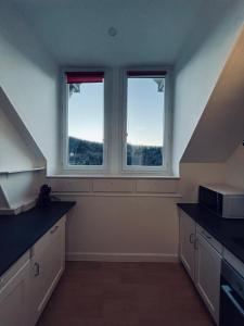 pusta kuchnia z dwoma oknami i schodami w obiekcie NEW : Maison avec vue Montagne w mieście Mont-Dore