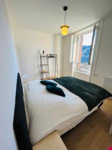 a bedroom with a large bed with a window at Logement Romily avec vue Montagne in Le Mont-Dore