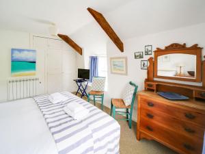 a bedroom with a bed and a dresser with a mirror at Trecarian in Port Isaac