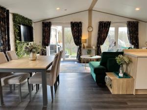 sala de estar con mesa y sofá verde en Coniston View 7 en Warton