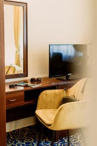 ヘーヴィーズにあるKorona Pension and Restaurantのデスク、テレビ、椅子が備わる客室です。