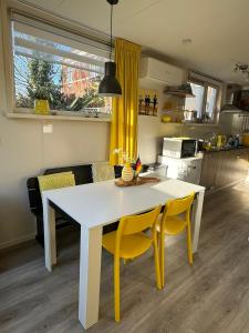 エグモント・アーン・ゼーにあるCoastal Dreamingのキッチン(白いテーブル、黄色い椅子付)