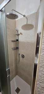 a bathroom with a shower with a glass door at la casa nella roccia in Scontrone