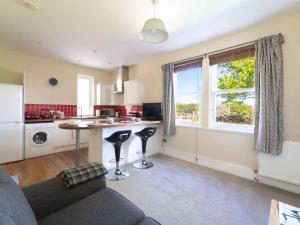 a kitchen and living room with a table and a window at Deerside, Tobermory in Tobermory +8 photos