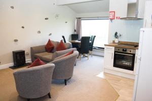 a living room with a couch and chairs and a kitchen at Howe Top in Mungrisdale