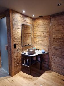 a bathroom with a sink in a wooden wall at Boutique Lodge Spycher in Saas-Fee