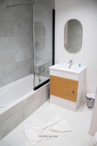 La salle de bains est pourvue d'un lavabo blanc et d'une douche. dans l'établissement Hôtel Suisse Tunis, à Tunis