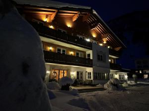 a building in the snow at night at Hotel Acerina Superior in Lech am Arlberg