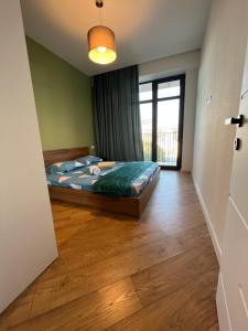 een slaapkamer met een bed en een groot raam bij Archi apartments 4 in Tbilisi City