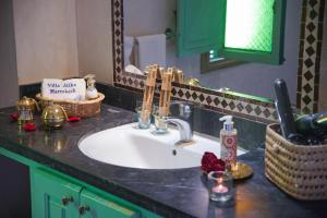 La salle de bains est pourvue d'un lavabo et d'un miroir. dans l'établissement Villa Atika Maison d'Hôtes & Spa, à Marrakech