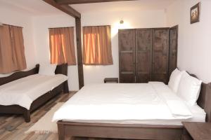 - une chambre avec 2 lits et une armoire en bois dans l'établissement Vila Toplika, à Kara Agach