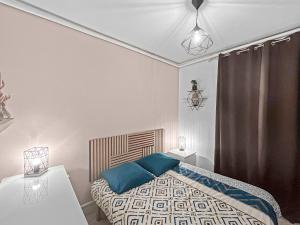 a bedroom with a bed with blue pillows at L'Esprit de Seine in Asnières-sur-Seine