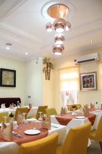 a dining room with tables and chairs and a chandelier at Palazzo Dumont Hotel in Ikota