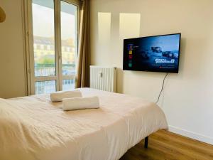 - une chambre avec un lit et une télévision murale à écran plat dans l'établissement La Coloc' - Centre ville - Gare, à Saint-Brieuc