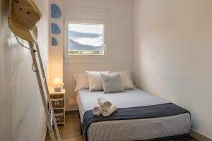 a small bedroom with a bed and a window at Apartamento con terraza, vistas playa y montaña in Hospitalet de l'Infant