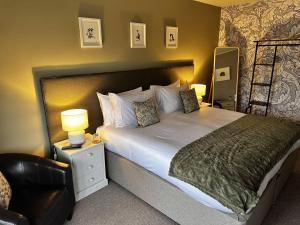 um quarto com uma cama grande e uma cadeira em The Lenchford em Worcester