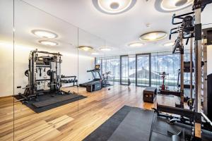 a gym with treadmills and machines in a room at Golden Hill Apt Enjoy in Dobbiaco