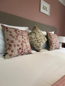 1 cama con almohadas y sábanas y almohadas blancas en The Lenchford en Worcester