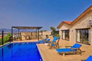 Villa con piscina y sillas azules en Villa Yaren / Kalkan, en Kas