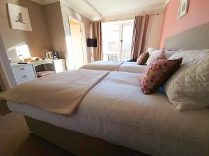 a bedroom with two beds and a window at The Lenchford in Worcester