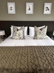 um quarto com uma cama grande com lençóis brancos e almofadas em The Lenchford em Worcester
