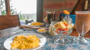 uma mesa coberta com pratos de comida e copos de bebidas em Glamping La Montaña 