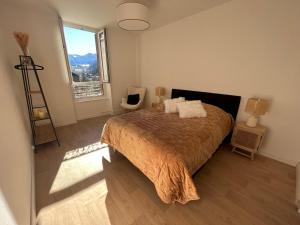 a bedroom with a bed and a large window at Logement Romily avec vue Montagne in Le Mont-Dore +3 photos