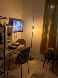 a living room with a table and a television at Le Pretty Spot - Studio à Bobigny in Bobigny