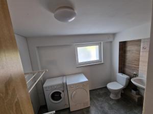 uma casa de banho com uma máquina de lavar roupa e um WC em Velo Invest em Koło