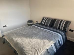 a bedroom with a large bed with black and white pillows at Elm Road leyton in London