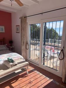 1 dormitorio con 1 cama y una gran puerta corredera de cristal en CASA EL GARDO, en Sayalonga