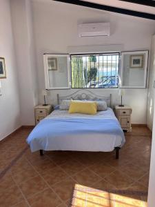 Dormitorio con cama con almohada amarilla en CASA EL GARDO, en Sayalonga