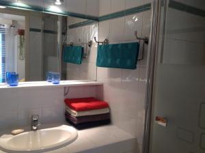 uma casa de banho com um lavatório e um chuveiro com um banco vermelho em Allées Provençales em Aix-en-Provence