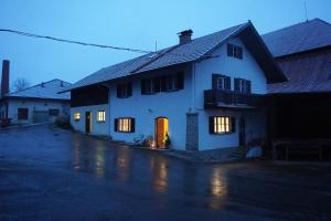 ein weißes Haus mit nachts beleuchteten Türen in der Unterkunft Oide Schreinerei in Steingaden