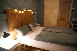 ein Schlafzimmer mit einem großen Bett mit Beleuchtung in der Unterkunft Oide Schreinerei in Steingaden