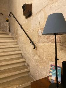 een lamp op een tafel naast een trap bij Charming Central Townhouse in Sliema steps from Promenade and Sliema Ferry in Sliema