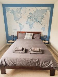 a large bed with a large map on the wall at Charming 2BR Townhouse with Games Room in Hull