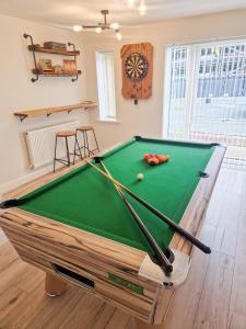 a pool table with balls and bats on it in a room at Charming 2BR Townhouse with Games Room in Hull