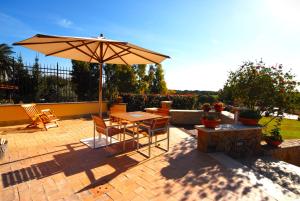 a patio with an umbrella and a table and chairs at Valle dei Casali B&B in Rome