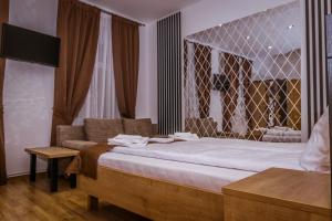 ein Schlafzimmer mit einem großen Bett und einem Sofa in der Unterkunft 4Rooms Central Sibiu in Sibiu