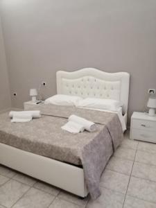 una camera da letto con un letto bianco con due asciugamani di Francesco Home a Napoli