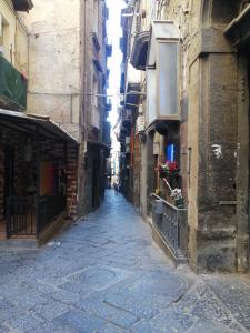un vicolo con edifici e una persona che cammina per la strada di Francesco Home a Napoli